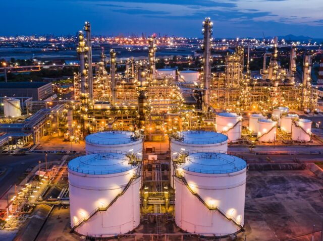 industrial oil and gas LPG refinery industry and commercial storage facilities import and export international by sea transport vessels aerial view at night in Thailand