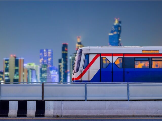 Bangkok SkyTrain stops on train tracks with blurred city background on night scene and copy space, Sky Train is a mass transit system in Bangkok to assist facilitate and  fast journey