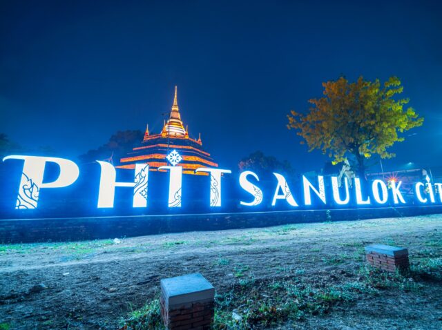 Text letter light Phitsanulok city and Chedi of Wat Ratchaburana at the Nan River and the park at night in Phitsanulok,Thailand.