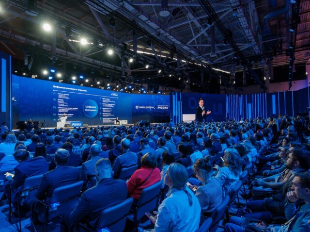 Moscow - February 6, 2024: Packed auditorium with attendees focused on a keynote speaker at a professional corporate event.